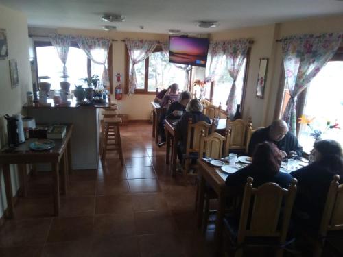 grupa ludzi siedzących przy stolikach w restauracji w obiekcie HOSTERIA Auroras de Fuego w mieście Ushuaia