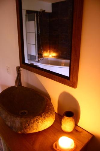a bathroom with a sink and a mirror and a candle at maison neuve en bois près de Pairy Daisa in Brugelette