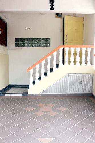 a staircase in a building with a yellow door at The Maple Homestay @ Kota Laksamana Melaka in Melaka
