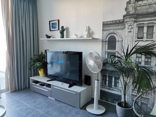 a living room with a flat screen tv and a fan at Duplex Maisonette with Heated P-Pool and Jacuzzi in St Julian's