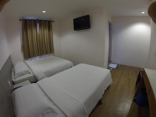 Habitación pequeña con 2 camas y TV. en Hotel Kinabalu, en Kota Kinabalu