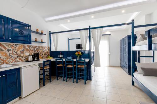 - une cuisine avec des armoires bleues et des lits superposés dans l'établissement Ammos stegna, à Archangelos