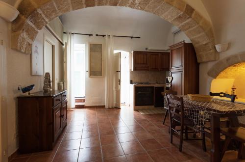 a kitchen with an archway and a table with chairs at Alimarta in Monopoli