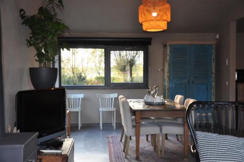 a living room with a table and a television at Studio Kilsdonk in Dinther