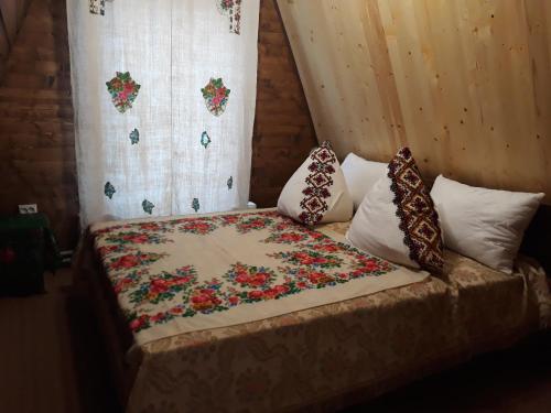 un letto con una coperta e cuscini di Oak House a Palyanytsya