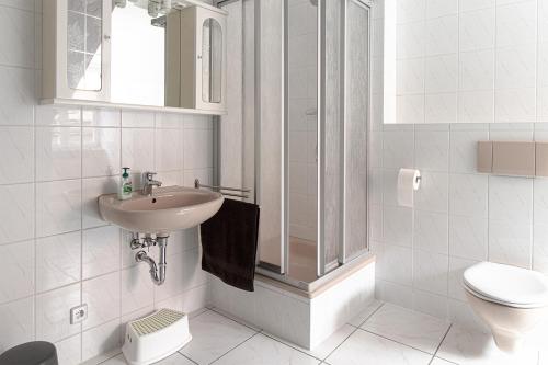 a white bathroom with a sink and a toilet at Ferienwohnungen Bockstraße in Quedlinburg