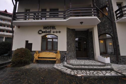 a hotel with a bench in front of a building at Hotel Cerbul in Statiunea Borsa