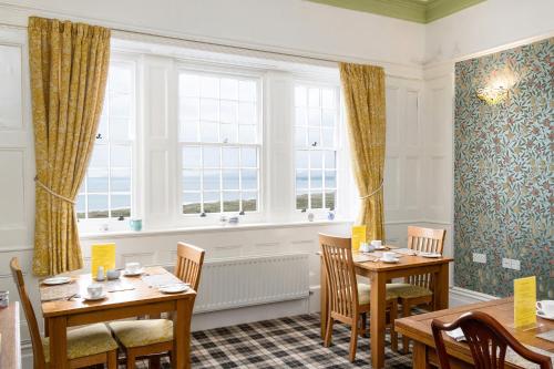 a dining room with two tables and a window at Crown Lodge in Harlech