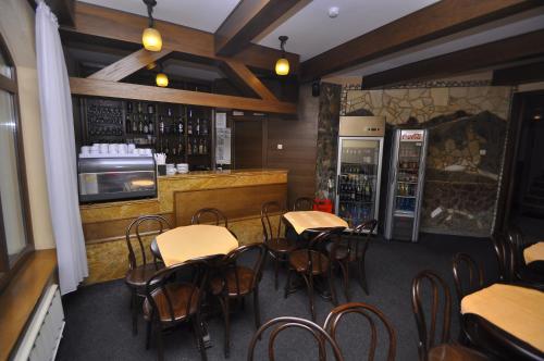 un restaurant avec un bar doté de tables et de chaises dans l'établissement Hotel Cerbul, à Statjunea Borsa