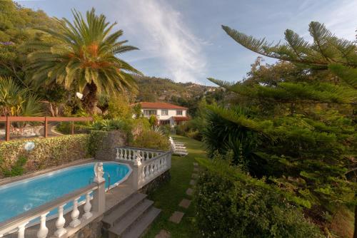 a swimming pool in a garden with a fence at Pool Villa with Botanical Garden in Funchal