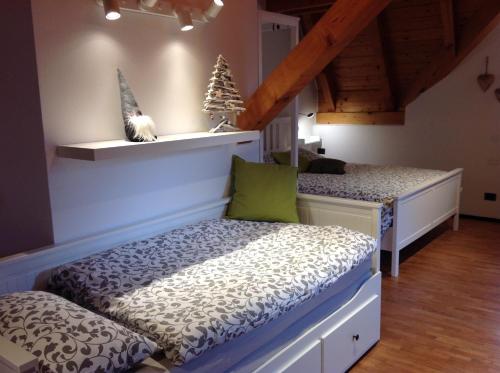 a bedroom with two beds and a cat sitting on a shelf at VILLA ROOMS in Laives