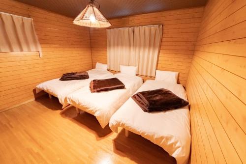 een kamer met 2 bedden in een houten kamer bij Nakajima Park West House / Vacation STAY 5418 in Sapporo