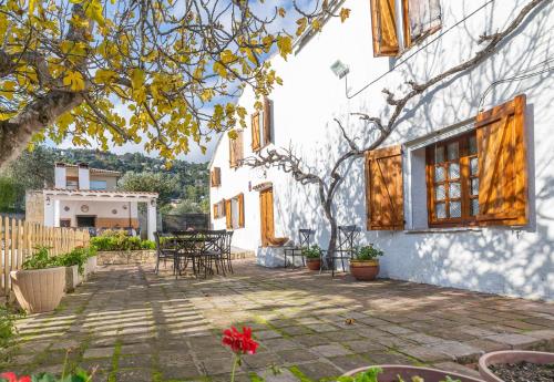 a patio of a white house with a tree at Masia Can Magan Lux, Ideal Grupos 20pax in Palafolls