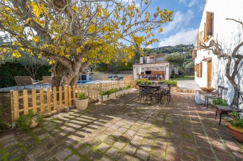 a patio with a tree and a table and chairs at Masia Can Magan Lux, Ideal Grupos 20pax in Palafolls