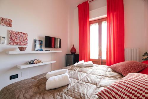 a bedroom with a bed with red curtains and a window at Le Stanze Di Brando E Nico in Tricase