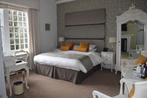 a bedroom with a large bed and a large mirror at Langtry Manor Hotel in Bournemouth