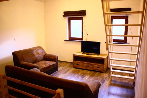 a living room with a couch chair and a television at maison neuve en bois près de Pairy Daisa in Brugelette