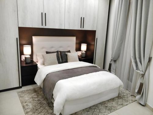 a bedroom with a large white bed with white cabinets at Central Rooms - Near Valletta & Sliema - Best Bus Lines in Hamrun