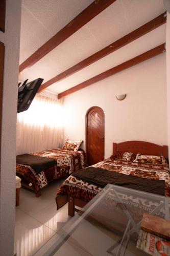 a hotel room with two beds and a window at Family House in Lima
