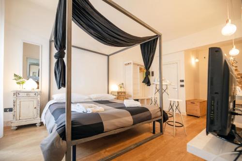 a bedroom with a canopy bed and a flat screen tv at Le Stanze Di Brando E Nico in Tricase