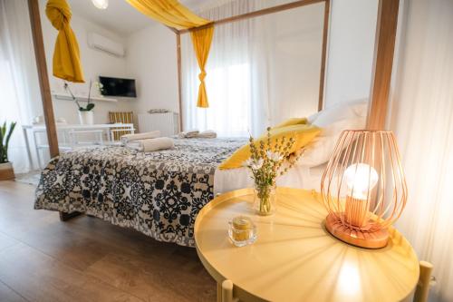 a bedroom with a bed and a table with flowers on it at Le Stanze Di Brando E Nico in Tricase