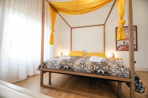 a bedroom with a canopy bed with yellow curtains at Le Stanze Di Brando E Nico in Tricase