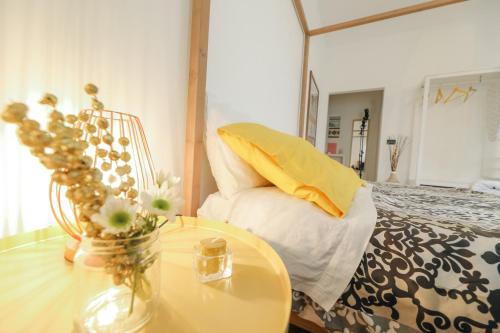 a bedroom with a bed and a table with a vase of flowers at Le Stanze Di Brando E Nico in Tricase