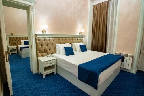 a bedroom with a large bed with a blue carpet at La Casa Sahil in Baku