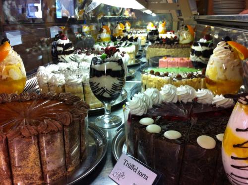 uma exibição de bolos e outras sobremesas numa padaria em Tulip Family Apartments em Eger