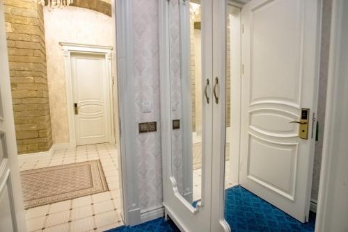 uma casa de banho com um chuveiro e uma porta branca em La Casa Sahil em Baku
