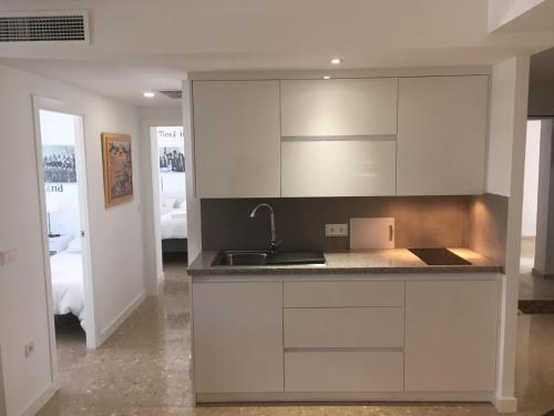a kitchen with white cabinets and a sink at Conde de Vallellano in Córdoba