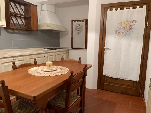 a kitchen with a wooden table and a wooden door at Casa La Stadera in Montepulciano