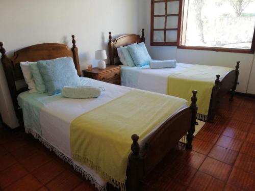 a bedroom with two beds with yellow and blue sheets at Quintinha das Lombas in Porto Santo