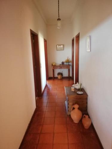 a hallway with a table and vases in a room at Quintinha das Lombas in Porto Santo