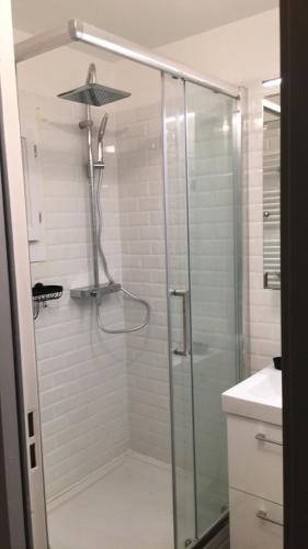 une douche avec une porte vitrée dans une salle de bain dans l'établissement T2 Rez de jardin 300m Plage de Beaucours Sanary sur Mer, à Sanary-sur-Mer