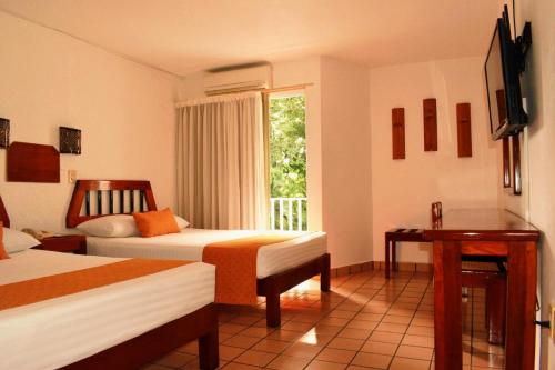 Cette chambre comprend 2 lits et une fenêtre. dans l'établissement Hotel Maya Palenque, à Palenque