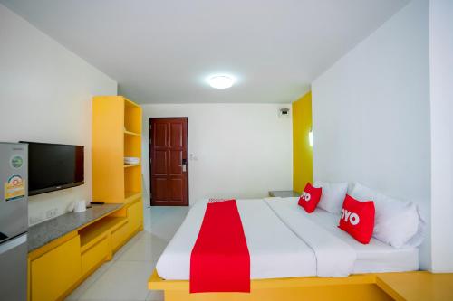 a bedroom with a bed with red pillows and a tv at OYO 460 Int Place in Bangkok