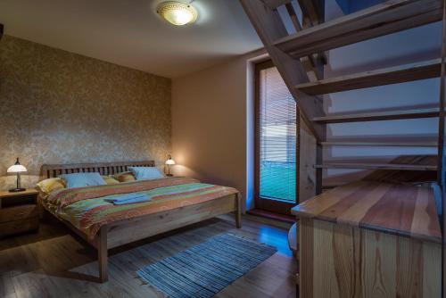 1 dormitorio con cama y ventana grande en KAPINA sk - Holiday Homes, en Liptovská Sielnica