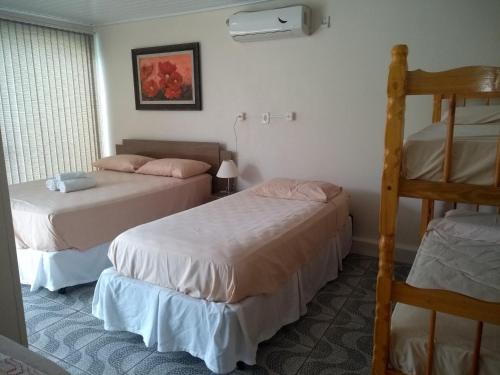 1 dormitorio con 2 camas y 1 litera en Apart São Gabriel en São Gabriel