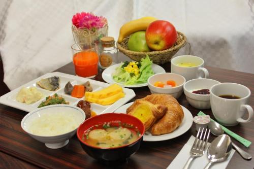 a table topped with plates of food and cups of coffee at Hotel Mark-1 Tsukuba in Tsukuba