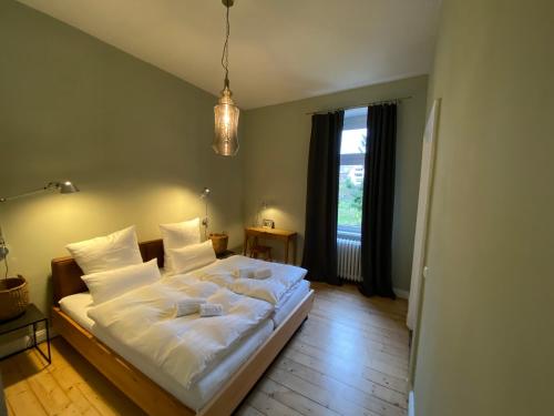 una camera da letto con un letto con lenzuola bianche e una finestra di Fabelhaus a Traben-Trarbach