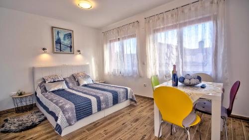 ein Schlafzimmer mit einem Bett und einem Tisch mit einem gelben Stuhl in der Unterkunft Studio apartment Margarita in Opatija