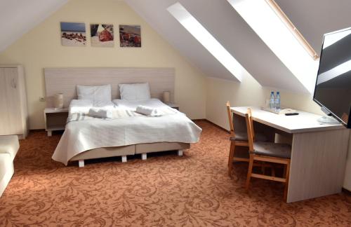 a bedroom with a bed and a desk with a computer at Paleo Premium in Władysławowo