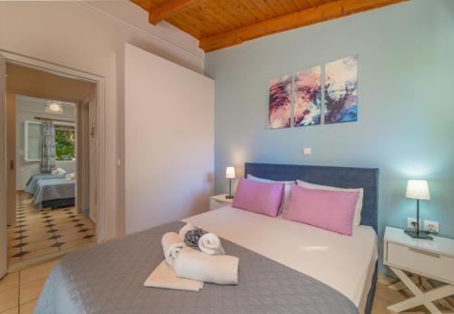a bedroom with a large bed with pink pillows at Flisvos Seaside Apartments in Lygia