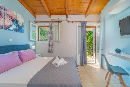 a bedroom with a bed and a chair at Flisvos Seaside Apartments in Lygia