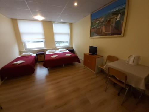 a room with two beds and a table in it at Viva Nord Hotel in Tallinn
