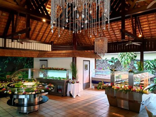 a restaurant with a buffet and flowers in a room at Maitai Bora Bora in Bora Bora