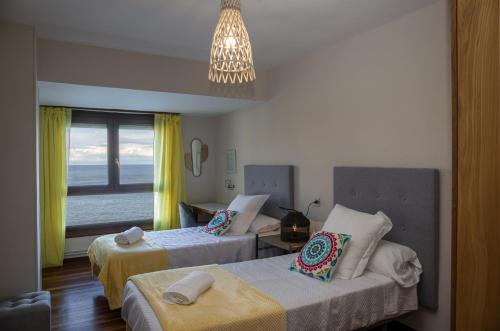 a hotel room with two beds and a window at Sea Coast Lekeitio by HomeBilbao in Lekeitio