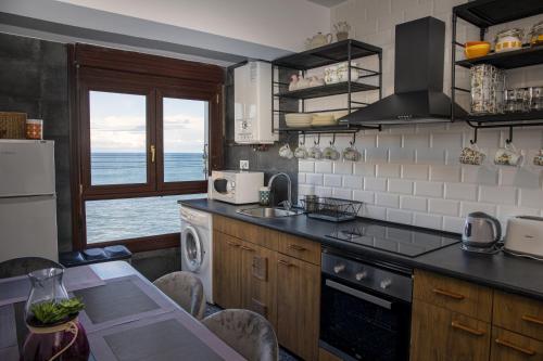 a kitchen with a table and a view of the ocean at Sea Coast Lekeitio by HomeBilbao in Lekeitio