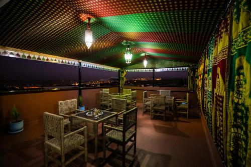 a restaurant with tables and chairs and green lights at Dar Layali Fez in Fès